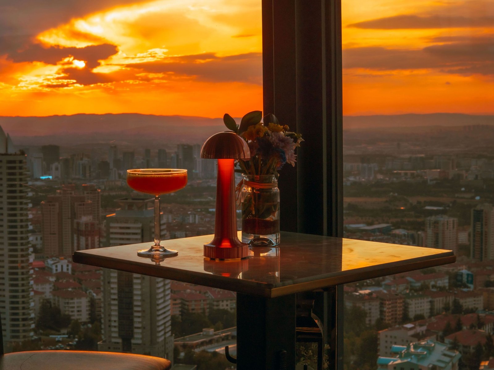 Enjoy a stunning sunset view over Ankara with a cocktail on a rooftop bar.